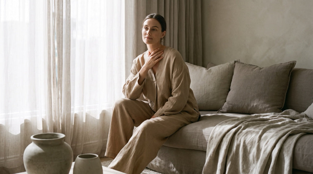 Femme sereine, la main posée près du cou, lumière naturelle chaude