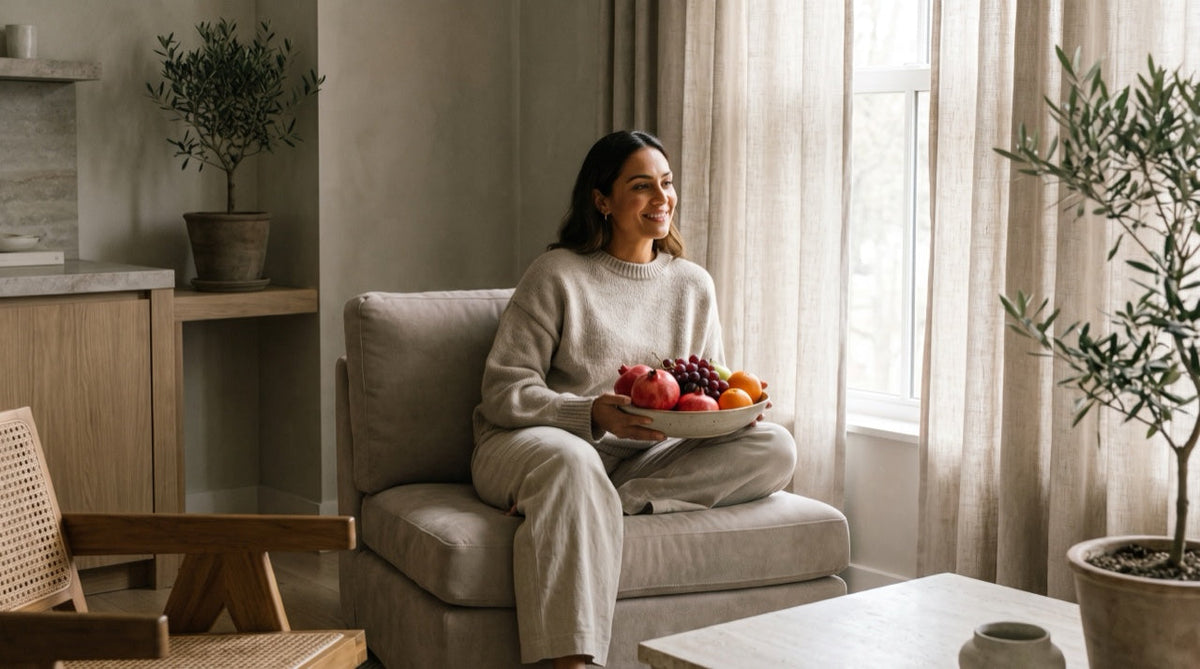 Femme rayonnante à la peau lumineuse tenant un fruit frais, lumière naturelle chaude